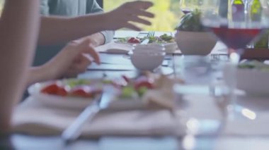 Arkadaşlar ya da evde aile yemeği sırasında ızgara etle karışık salata yemeği. Eller yakın çekimde.