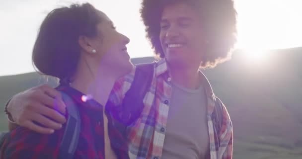 Чоловік і жінка посміхаються і сміються разом на свіжому повітрі під час заходу сонця. — стокове відео