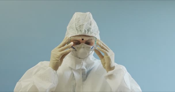 Dottore in tuta protettiva con maschera viso, occhiali e guanti ritratto. Infermiera in tuta protettiva con maschera viso, occhiali e guanti. Donna che indossa una suite di protezione — Video Stock