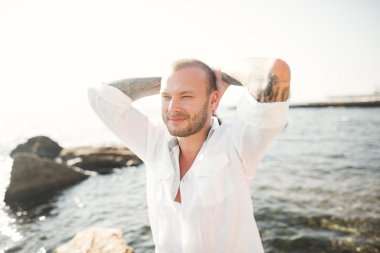 yakışıklı model adam taş denizin kenarında poz