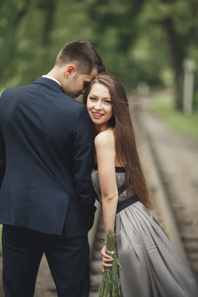 Hermosa joven pareja posando al aire libre después de la ceremonia — Foto de Stock