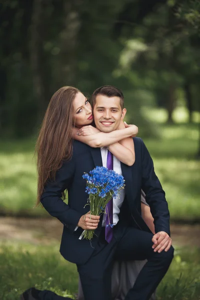 Young beautiful couple, girl with perfect dress posing in park — Stock Photo, Image