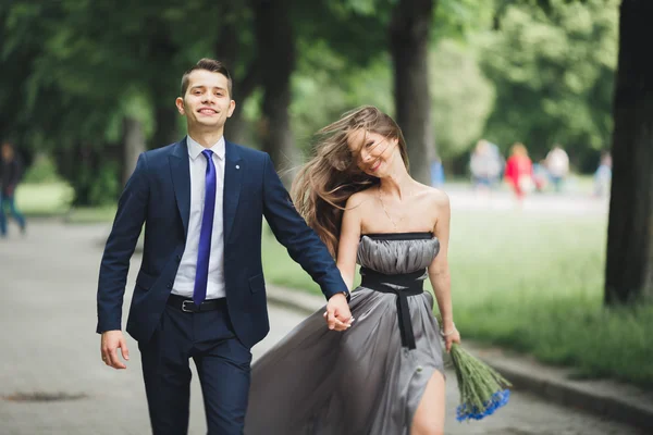 Bonito jovem casal posando ao ar livre após a cerimônia — Fotografia de Stock