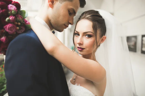 Retrato de feliz pareja de recién casados con ramo de flores — Foto de Stock