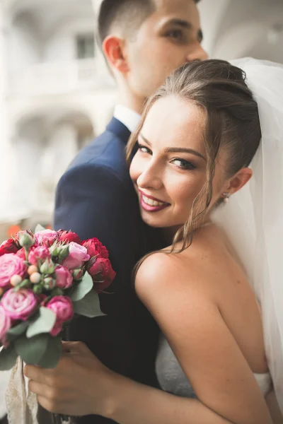 Porträt des glücklichen Brautpaares mit Blumenstrauß — Stockfoto