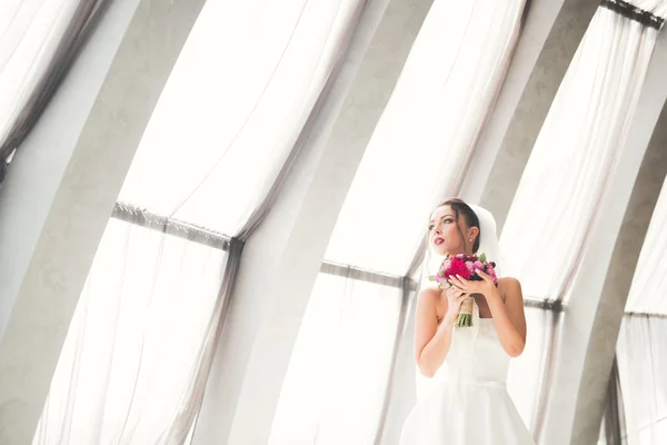 Beautiful bride with wedding bouquet posing in old city — Stock Photo, Image