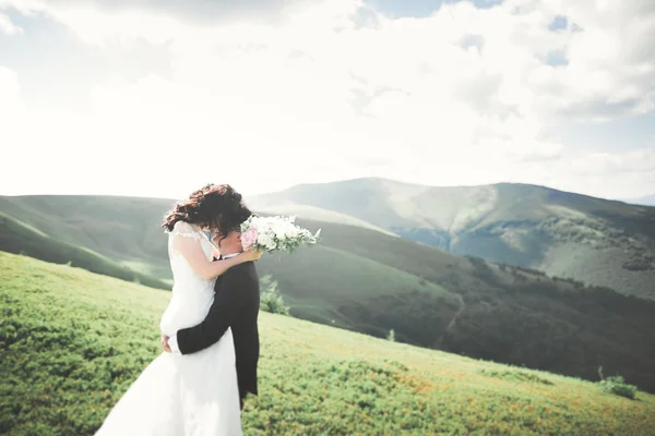 Hermosa pareja de boda, novia y novio, en el amor en el fondo de las montañas —  Fotos de Stock