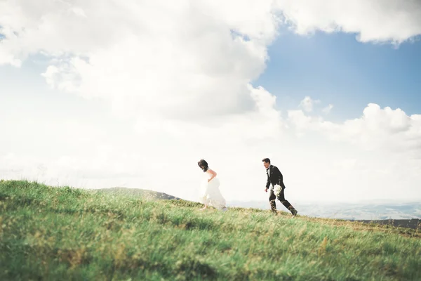 Прекрасна щаслива наречена і стильний наречений позує на тлі сонячних приголомшливих гір — стокове фото