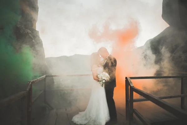 Couple de mariage heureux embrasser et étreindre près d'une haute falaise — Photo