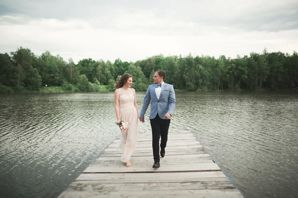 Pareja de boda, novia, novio caminando y posando en el muelle —  Fotos de Stock