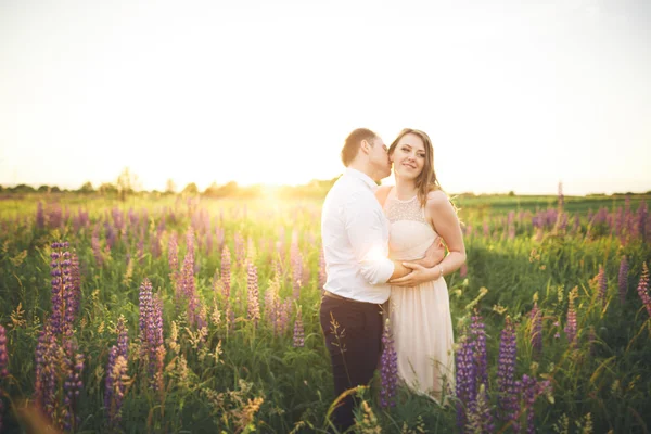 Sposa tiene sposi collo mentre lui la bacia nei raggi del tramonto — Foto Stock