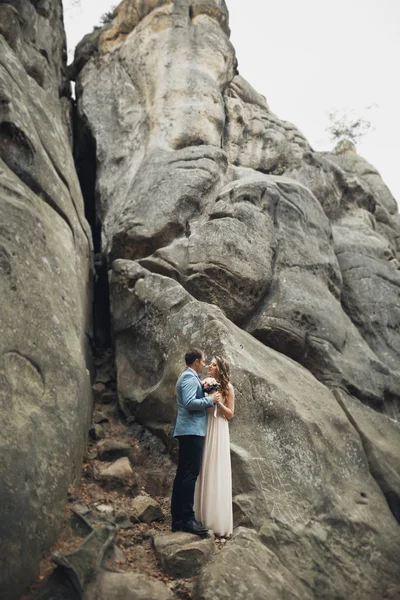 Couple de mariage heureux embrasser et étreindre près d'une haute falaise — Photo