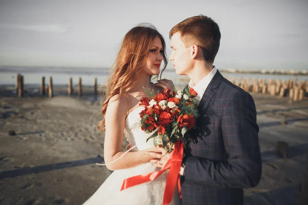 Casal feliz elegante elegante, noiva, lindo noivo no fundo do mar e do céu — Fotografia de Stock