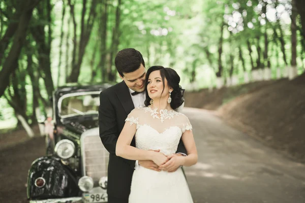 Casal lindo posando perto esplêndido carro retro — Fotografia de Stock