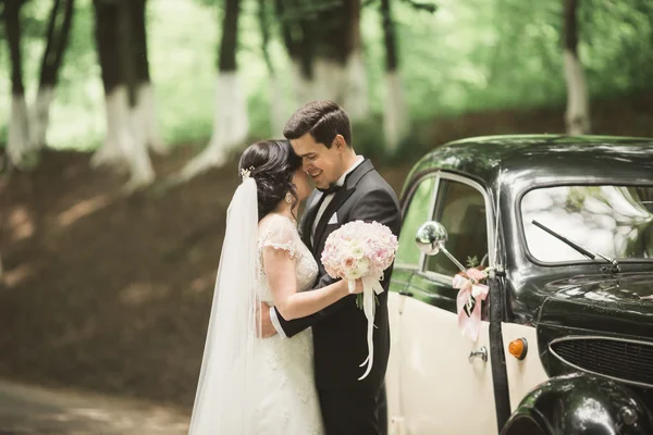 Casal lindo posando perto esplêndido carro retro — Fotografia de Stock