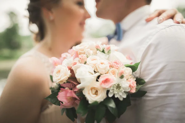 Bruden och brudgummen holding vackra bröllop bukett. Sjö, skog — Stockfoto