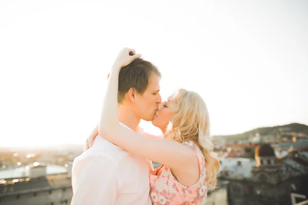 Close up retrato de feliz casal sorridente no amor posando no telhado com grandes bolas. Paisagem cidade — Fotografia de Stock