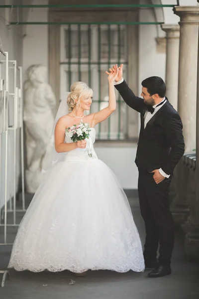 Bella coppia di nozze felice, sposa con abito lungo bianco in posa nella bella città — Foto Stock