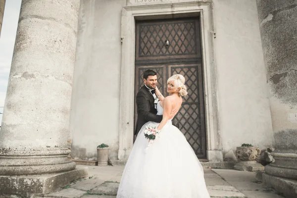 Hermosa boda romántica pareja de recién casados abrazos cerca del viejo castillo —  Fotos de Stock