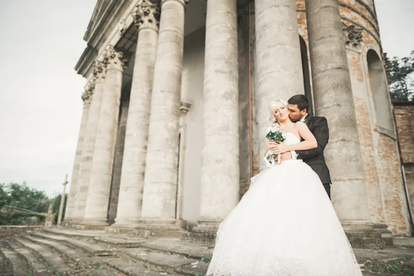 Bella coppia di sposi romantici che si abbracciano vicino al vecchio castello — Foto Stock