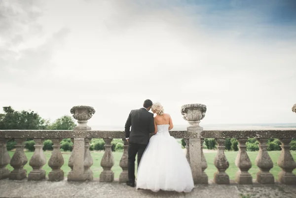 Hermosa boda romántica pareja de recién casados abrazos cerca del viejo castillo —  Fotos de Stock