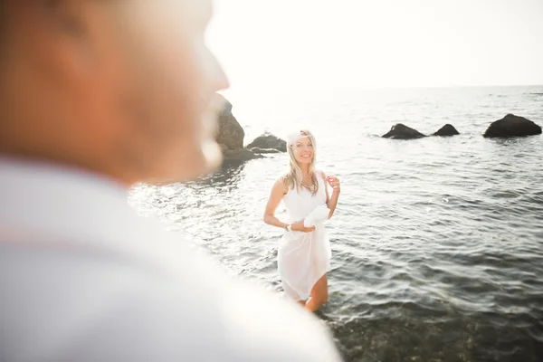 바다, 푸른 하늘 가까운 돌에 포즈 로맨틱 사랑 하는 커플 — 스톡 사진