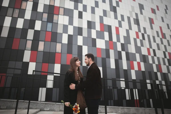 Elegante mooie paar poseren in de buurt van moderne glazen gebouw — Stockfoto