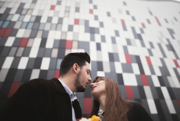 Élégant beau couple posant près du bâtiment en verre moderne — Photo