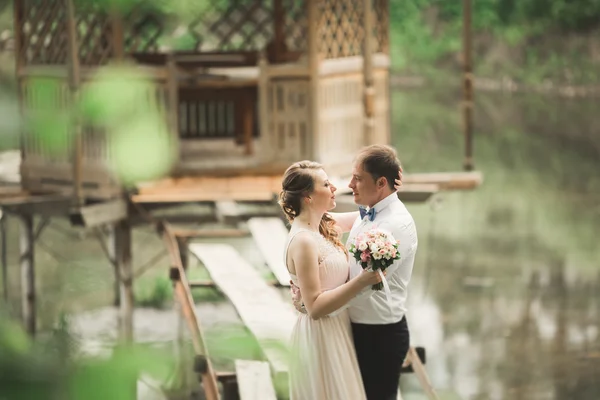 Sposo baci spose fronte mentre lei si appoggia a lui sorridente — Foto Stock