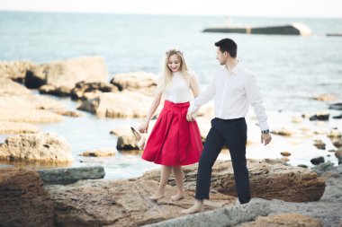 Deniz, mavi gökyüzü yakınındaki taş poz romantik sevgi dolu Çift