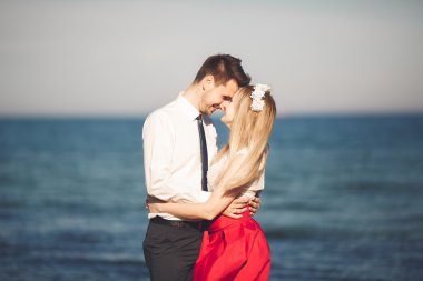 Genç mutlu çift holding birbirlerini etrafında gülümseyen Sahilde yürüyüş. Aşk hikayesi