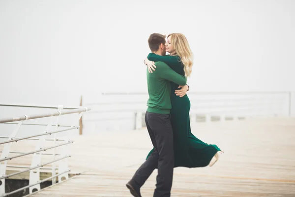 Adorável casal beijando e abraçando em uma doca do mar — Fotografia de Stock