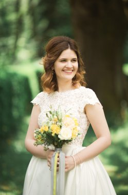 Gelin. Güzel sarışın kadın çiçek çelenk ve buket sıcak yaz gününde park