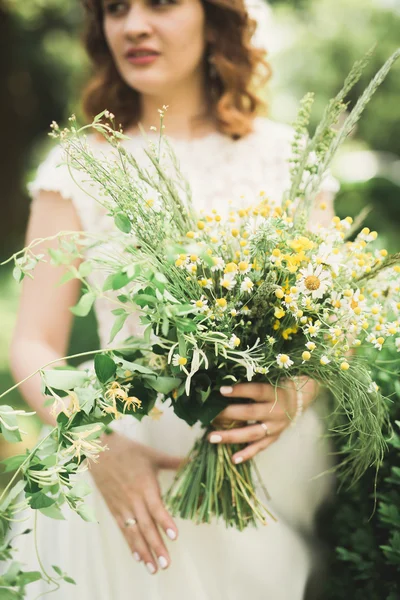 La novia sosteniendo ramo de flores en el parque. Boda — Foto de Stock