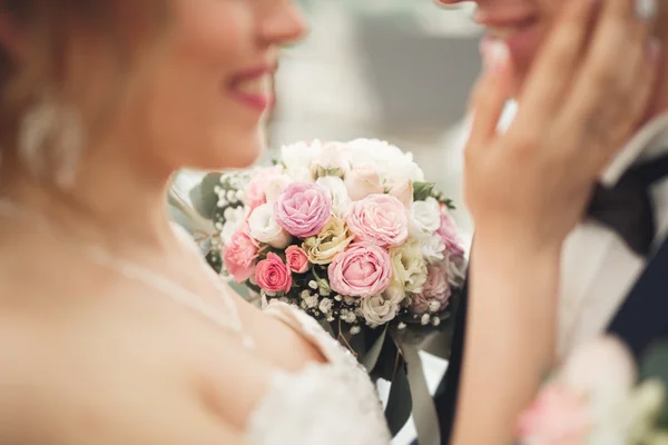 Appena sposati coppia di nozze posa e sposa tenendo in mano bouquet — Foto Stock