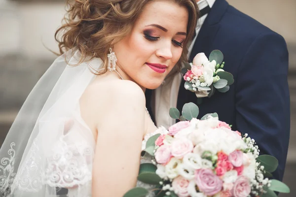 Juste marié couple de mariage posant et mariée tenant dans les mains bouquet — Photo