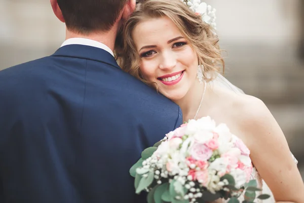 Pareja de recién casados posando y novia sosteniendo en las manos ramo —  Fotos de Stock