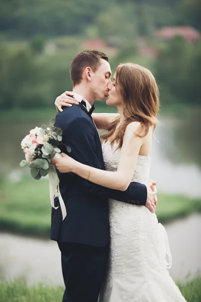 Pareja romántica de la boda, hombre y mujer, posando cerca del hermoso lago — Foto de Stock