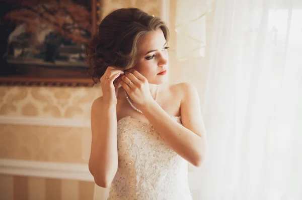 Novia de lujo en vestido blanco posando mientras se prepara para la ceremonia de boda —  Fotos de Stock