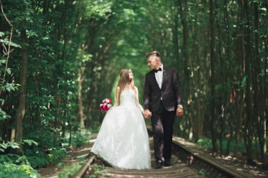 Genç düğün çift, gelin ve damat bir demiryolundan poz