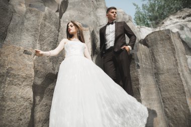 Evlilik çift büyük taşlar üzerinde poz. Gelin ve damat