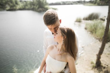 Öpüşen düğün çifti güzel manzarada kalıyor.