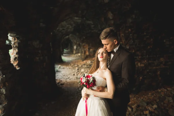 Güzel bir peri masalı yeni evli çift eski ortaçağ şatosunun yakınlarında sarılıyor. — Stok fotoğraf