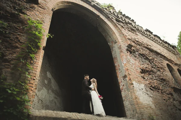 Belo conto de fadas casal recém-casado abraçando perto do velho castelo medieval — Fotografia de Stock