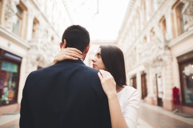 Güzel düğün çift, Gelin, damat öpüşme ve eski bina arka plan karşı sarılma