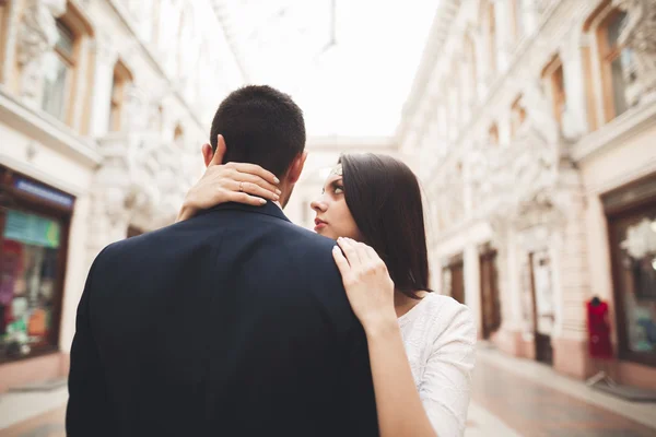 Beautiful bröllop par, bruden, brudgummen kyssas och kramas mot bakgrund av gamla byggnad — Stockfoto