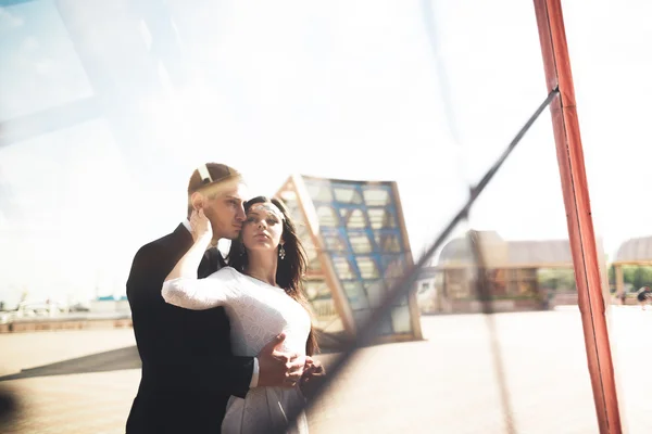 Elegante casal amoroso beijando e abraçando perto de edifício moderno — Fotografia de Stock