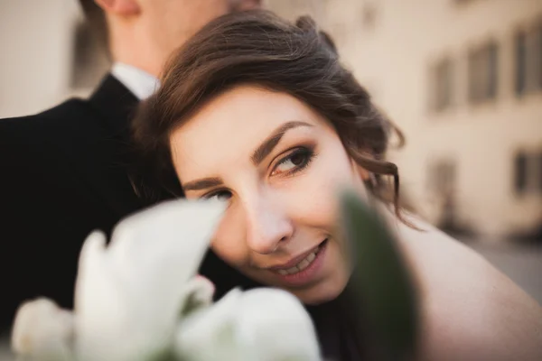Šťastný, Svatební pár, ženich, nevěsta s růžové šaty objímání a usmívá se vzájemně na pozadí stěny v zámku — Stock fotografie