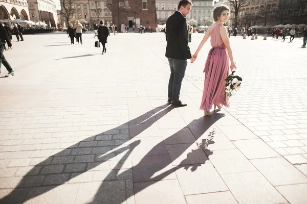 Bröllop. vackert par, brud med rosa brudklänning promenad i den gamla staden Krakow, deras skuggor — Stockfoto