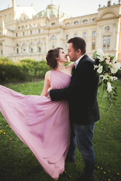 婚礼。对夫妇。克拉科夫。粉红色的连衣裙和剧院背景构成的新郎新娘 — 图库照片